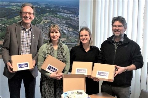 Freuen sich über ein neues Geschenk für die Brühler Babys: Bürgermeister Dr. Ralf Göck (li) und Oliver Embach (re) sowie Sandra Kosel und Sarah Ilhan, die die Box zusammenstellten.