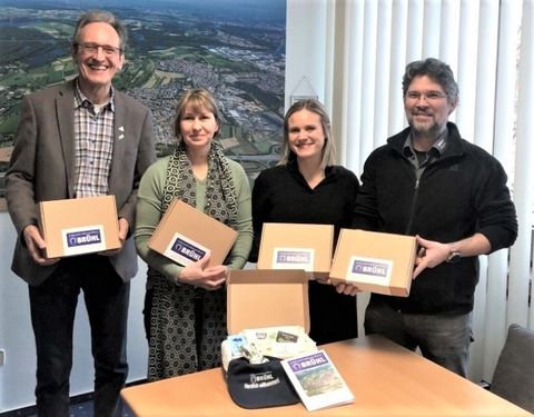 Freuen sich über ein neues Geschenk für die Brühler Babys: Bürgermeister Dr. Ralf Göck (li) und Oliver Embach (re) sowie Sandra Kosel und Sarah Ilhan, die die Box zusammenstellten.