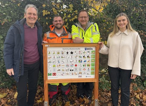 Bürgermeister Dr. Ralf Göck, Vorarbeiter Dennis Riehl, Bauhofleiter Marcus Schütterle, Initiatorin Lena Krug und mit der vom Bauhof Brühl erstellten Tafel auf dem Geierstraße - Spielplatz