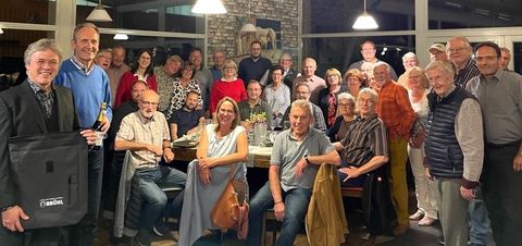 Bernd Zimmermann mit seinem neuen „Brühler Rucksack“ (li) und Bürgermeister Dr. Ralf Göck mit „Stickelspitzer-Sekt“ und einer Freikarte für die Kollerfähre sowie alle Gäste und Gastgeber des jährlichen Otterstadt-Brühler Ratstreffens.