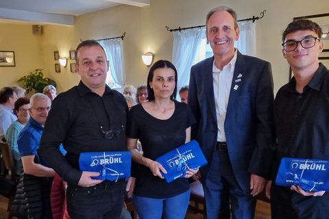 Bürgermeister Dr. Ralf Göck (2. v. re.) überreicht die Brühler Kochschürzen an die Pächterfamilie Dichris und wünscht viel Erfolg und einen guten Start am neuen Standort.